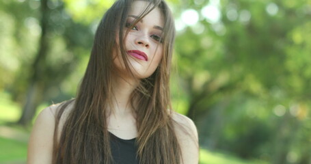 Naklejka premium Pretty girl waving hello and inviting to come with hand and finger outdoors