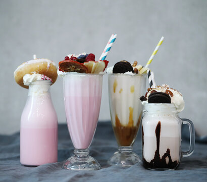 three milkshakes sitting next to each other on a table, milkshake, drink milkshakes together, milk, creamy, drinks, vanilla smoothie explosion