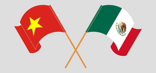 Crossed and waving flags of Vietnam and Mexico