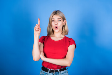 Fototapeta premium Young and attractive caucasian blonde girl in casual clothes with open mouth showing idea gesture isolated on blue studio background.