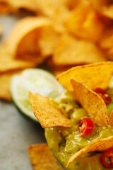 Spicy Guacamole With Tortilla Chips and Fresh Ingredients on a Table