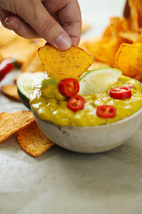 Spicy Guacamole With Tortilla Chips and Fresh Ingredients on a Table