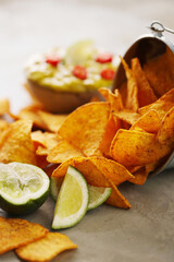 Spicy Guacamole With Tortilla Chips and Fresh Ingredients on a Table