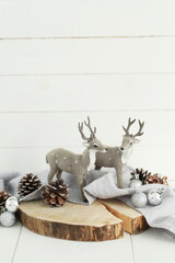 Christmas deer toys with cones on wooden table