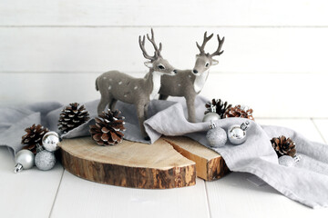 Christmas deer toys with cones on wooden table
