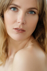 Fototapeta premium Close view of young blond woman looks at camera and pose at home