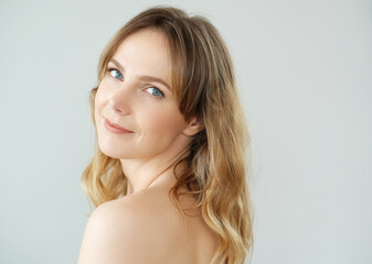 Close view of young blond woman looks at camera and pose at home