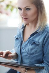 Fototapeta premium Image of young woman lworking on digital tablet at home