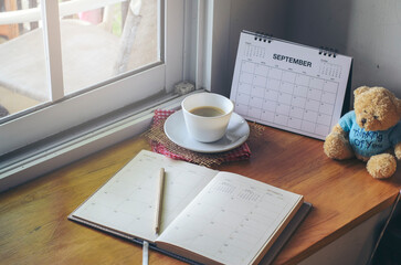 Desk for student education concept. Calendar, Book, cup of coffee, and pencil for study for exam placed on wooden School table for student plan to work at home.
