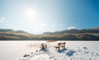 winter landscape with lake and mountains on a bench