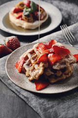 Beautifully decorated delicious sweet Belgian waffles with strawberries on the plate