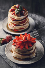 Beautifully decorated delicious sweet pancakes with strawberries on the plate