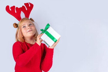 Christmas holiday background with funny blond girl. Little kid girl in red Christmas sweater and...