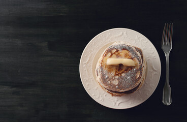Healthy summer breakfast with classic pancakes with a slice of melted butter in the plate