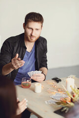 A handsome young man playing cards with his friends at a party