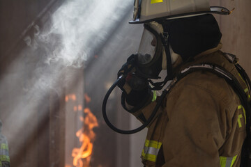 Firefighter in burning house with smoke