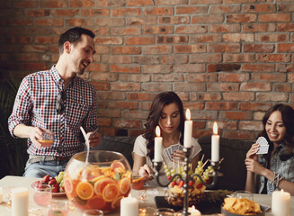 Friends play cards on the couch and drink 