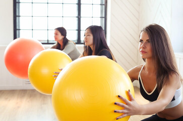 Group of Gym young women exercising with Pilates balls in fitness club 