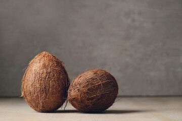 Two whole tasty fresh coconuts on a dark background