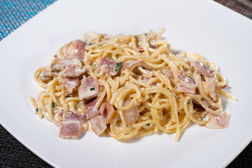 carbonara pasta with cream and bacon close up on white plate