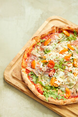 Picture of delicious hot whole pizza with vegetables on a wooden board