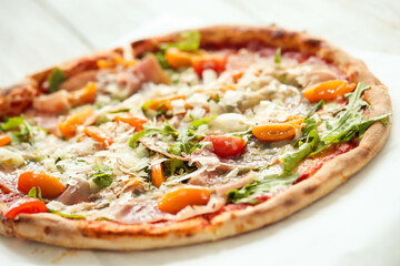 Picture of delicious hot whole pizza with vegetables on a wooden background