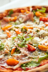 Close view of delicious hot whole pizza with vegetables 