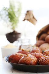 Delicious baked hot potato with spices on a wooden background