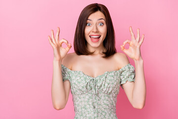 Photo of pretty sweet lady raise two arm show okey symbol satisfied enjoy good job quality clothes isolated on pink color background