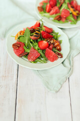 Summer tasty salad with grapefruit , strawberries, arugula and pecan nut in the plate