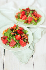 Summer yummy salad with grapefruit , strawberries, arugula and pecan nut in the plate