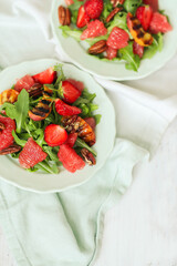 Summer yummy salads with grapefruit , strawberries, arugula and pecan nut in the plate