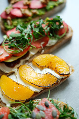 Close view of various tasty fresh Bruschetta (sandwiches) with cherry tomatoes, mozzarella cheese and herbs on a white background.