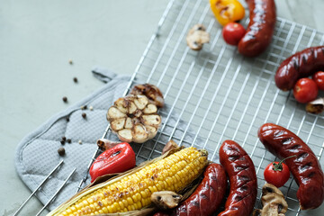 Delicious hot grilled food with sausage,corn and other vegeables on a mesh grid