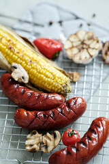 Delicious hot grilled food with sausage,corn and other vegeables on a mesh grid