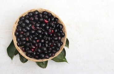 Top View of Jamun or Black Plum Fruit a Bamboo Basket with Leaves Isolated on White Background with Copy Space, Also Known as Malabar Plum, Syzygium Cumini or Jambolan