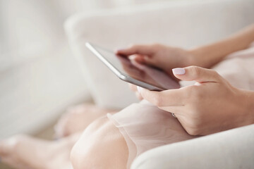 Women’s beautiful groomed hands holding a digital tablet
