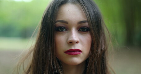 Portrait of serious young woman in 20s looking to camera in outdoors