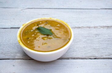 Closeup of Ghugni or Yellow Pea Curry in a Bowl Isolated on White Wooden Background with Copy Space