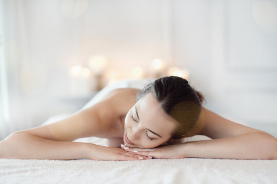 Relaxed beautiful young woman lying on the couch after massage in the spa