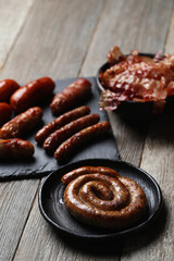 Delicious homemade hot grilled sausage on a wooden black cutting board 