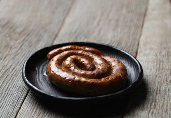 Delicious homemade hot grilled sausage in a black plate