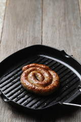 Delicious homemade hot grilled sausage in a black pan