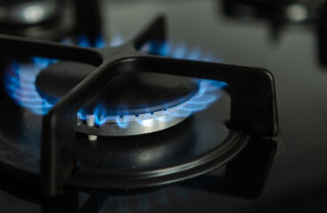 Close-up view of the blue flame of natural gas burning in the burners of a modern kitchen