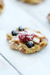 Breakfast of tasty Waffles with berries on a wooden surface