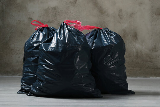 The big black garbage bags placed on the floor.