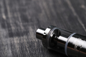 An electronic cigarette for smoking nicotine on a dark wooden background
