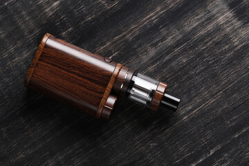 An electronic cigarette for smoking nicotine on a dark wooden background