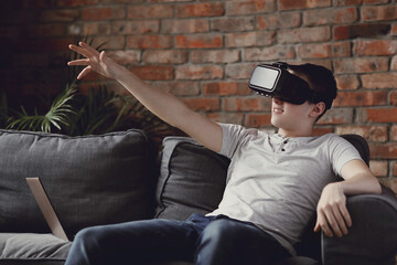 Teen playing with virtual reality glasses at home
