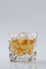 Whiskey with ice or brandy in a glass on a white background.